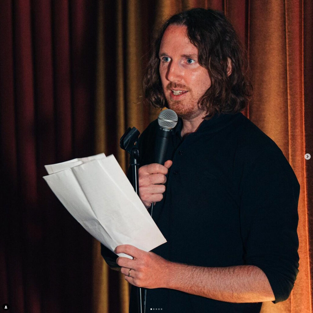 Vegar Tryggeseid komiker snakker i mikrofon på standup i Stavanger